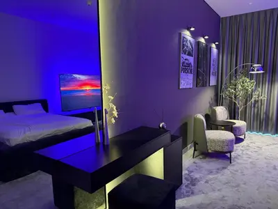 a purple bedroom with a bed and a desk and chair at Stylish Studio with Burj Khalifa Views in Dubai