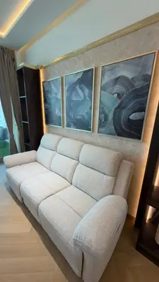 a white couch in a room with paintings on the wall at Beachside Palm Jumeirah 1 Br apartment in Dubai
