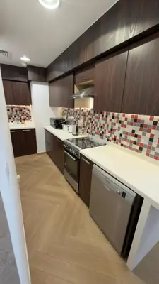a kitchen with wooden cabinets and a counter top at Beachside Palm Jumeirah 1 Br apartment in Dubai