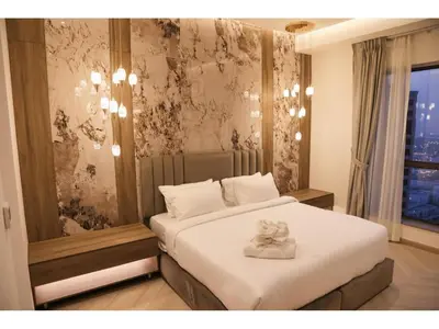 a bedroom with a bed with a towel on it at The bahar bloom stay in Dubai