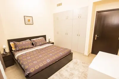 a bedroom with a large bed and a closet at Brand New 2BHK Fully Furnished Apartment in Warsan in Dubai
