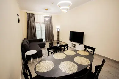 a living room with a table and a couch at Brand New 2BHK Fully Furnished Apartment in Warsan in Dubai
