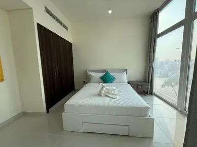 a bedroom with a white bed with a large window at Spacious Fully Furnished 6BR Villa in Damac Hill2 in Dubai