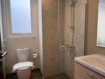 a bathroom with a shower and a toilet and a sink at Spacious Fully Furnished 6BR Villa in Damac Hill2 in Dubai