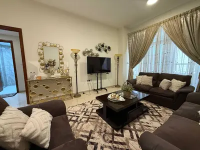 a living room with a couch and a table at Stylish & Fully Furnished 1BR in Laya Residence in Dubai