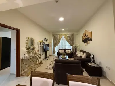 a living room with a couch and a table at Stylish & Fully Furnished 1BR in Laya Residence in Dubai