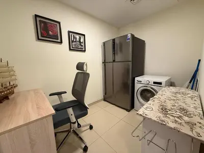 a kitchen with a refrigerator and a washing machine at Stylish & Fully Furnished 1BR in Laya Residence in Dubai