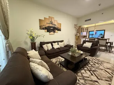 a living room with a couch and a table at Stylish & Fully Furnished 1BR in Laya Residence in Dubai