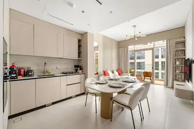 a kitchen and dining room with a table and chairs at VayK - Refined 1 BD Apartment in JVC in Dubai