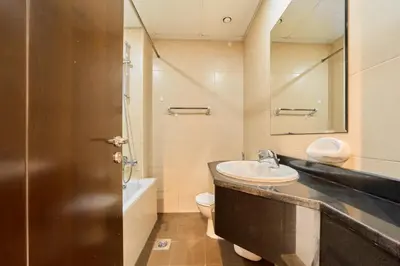 a bathroom with a sink and a toilet and a mirror at Peaceful 1BR with Balcony at Elite Residence Dubai in Dubai