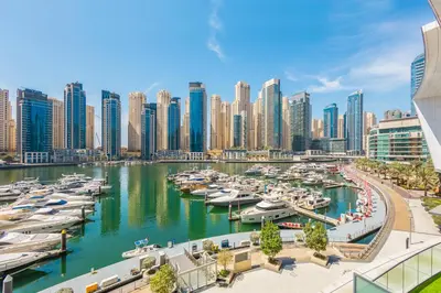 a city with boats docked in a marina at 2BR Marina View Steps from the Beach in Dubai