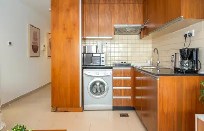 a kitchen with a dishwasher and a washing machine at Zapbed House-Modern Studio Apartment in Dubai Sports City in Dubai