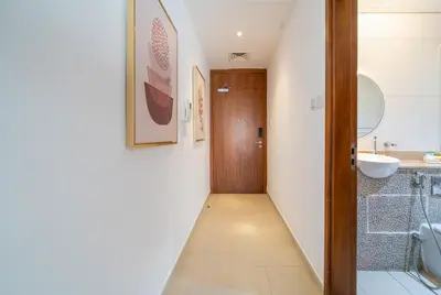 a hallway with a bathroom with a wooden door at Zapbed House-Modern Studio Apartment in Dubai Sports City in Dubai