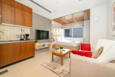 a large living room with a couch and a kitchen at Zapbed House-Modern Studio Apartment in Dubai Sports City in Dubai