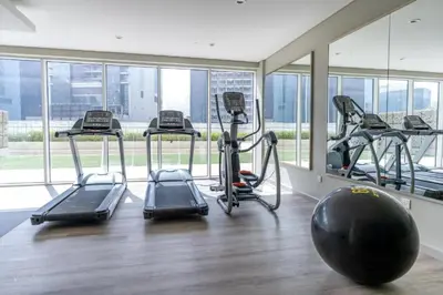 a gym with several treadmills and a large window at Modern 1BR Apt - Canal View in Dubai