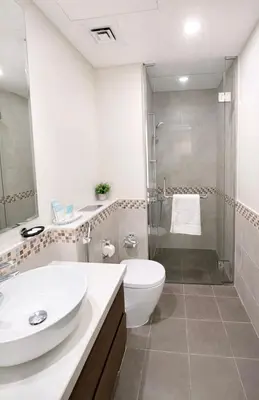 a bathroom with a sink and a toilet and a shower at Modern 1BR Apt - Canal View in Dubai