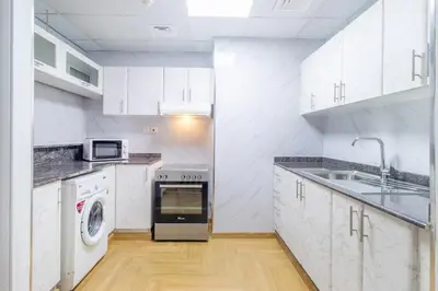 a white kitchen with a sink and a dishwasher at Luxury 2BR in Dubai Marina Man 1105 in Dubai