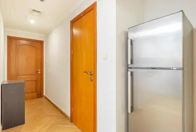 a kitchen with a refrigerator and a wooden door at Luxury 2BR in Dubai Marina Man 1105 in Dubai