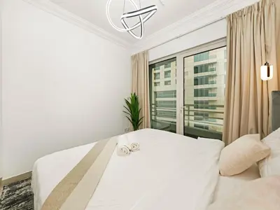 a bedroom with a large white bed with two wedding rings at Luxury 3BHK w Floating Bed in Dubai Marina Man 2501 in Dubai
