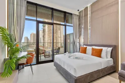 a bedroom with a large bed and a large window at Chic & Sleek Studio in Westwood Grande in Dubai