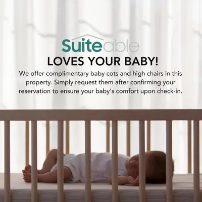 a baby laying on a bed in a crib at Chic & Sleek Studio in Westwood Grande in Dubai