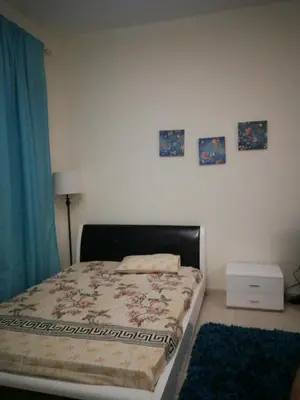 a bedroom with a bed and two pictures on the wall at Dubai Sports City home in Peaceful Location in Dubai