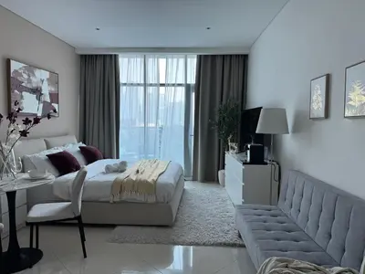 a white bedroom with a bed and a couch at Comfortable apartments on the Palm in Dubai
