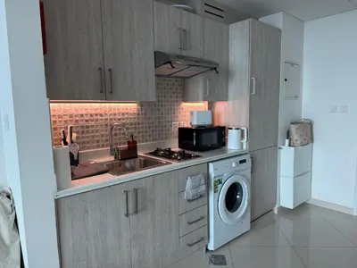 a kitchen with a sink and a washing machine at Comfortable apartments on the Palm in Dubai