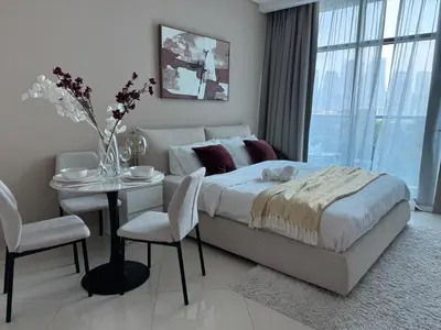 a bedroom with a bed and a table and chairs at Comfortable apartments on the Palm in Dubai
