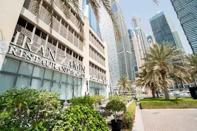 a building in a city with palm trees and buildings at Elegant 1-BDR with Panoramic Marina & Canal Views in Dubai