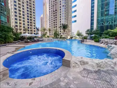 a large swimming pool in a city with tall buildings at MegaLuxury Beachfront with Panoramic Ain Dubai Views in JBR, Sleep 12 in Dubai