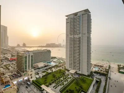 a view of a city with the ocean and a tall building at MegaLuxury Beachfront with Panoramic Ain Dubai Views in JBR, Sleep 12 in Dubai