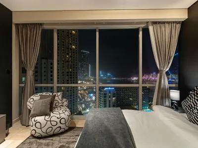 a bedroom with a large window with a bed and a chair at MegaLuxury Beachfront with Panoramic Ain Dubai Views in JBR, Sleep 12 in Dubai