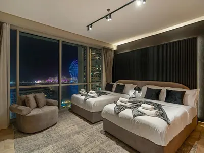 a hotel room with two beds and a large window at MegaLuxury Beachfront with Panoramic Ain Dubai Views in JBR, Sleep 12 in Dubai