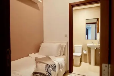 a bathroom with a bed and a sink and a mirror at Nivis find-3BHK Apartment-Burj vista- Connected to Dubai Mall in Dubai