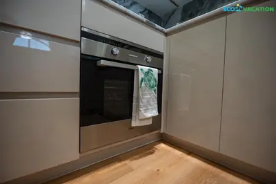 a kitchen with an oven with a towel hanging from it at Eco-Luxe Retreat - Minutes from Global Village in Dubai