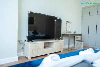 a living room with a large flat screen tv at Eco-Luxe Retreat - Minutes from Global Village in Dubai