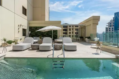 a pool with chairs and an umbrella on a building at Stunning VIP Penthouse JBR cinema&spa&pool in Dubai