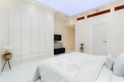a white bedroom with a large bed and a tv at Stunning VIP Penthouse JBR cinema&spa&pool in Dubai