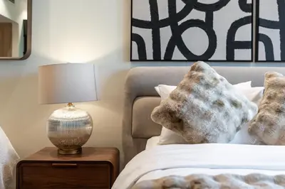 a bedroom with a bed and a table with a lamp at White Sage Discovery Gardens Renovated Studio next to Metro in Dubai