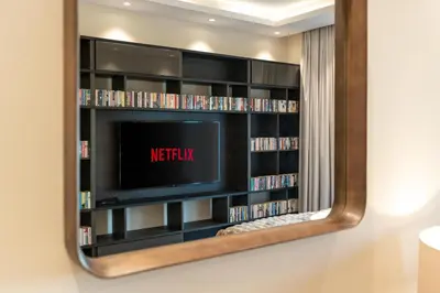 a mirror on a wall with a tv and dvds at White Sage Discovery Gardens Renovated Studio next to Metro in Dubai