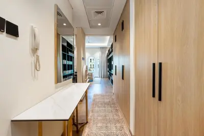 a hallway with a white counter and wooden cabinets at White Sage Discovery Gardens Renovated Studio next to Metro in Dubai