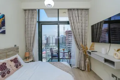 a bedroom with a bed and a view of a city at The Riviera Nook Cozy Stay in Dubai in Dubai