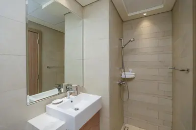 a white bathroom with a sink and a shower at The Riviera Nook Cozy Stay in Dubai in Dubai