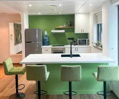 a kitchen with a white counter and green walls at Modern 1BR Apartment - Marina Walk in Dubai