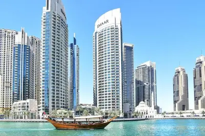 a boat in the water in front of a city at Modern 1BR Apartment - Marina Walk in Dubai