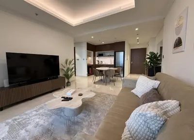 a living room with a couch and a flat screen tv at Coastal Chic at Emaar Beachfront 1BR in Dubai
