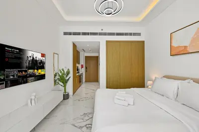 a white bedroom with a large white bed in a room at Estudio Coral en Dubai By BeBalmy in Dubai