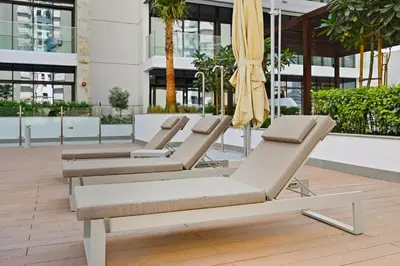four lounge chairs and an umbrella in a building at Estudio Coral en Dubai By BeBalmy in Dubai
