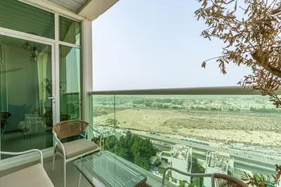 a balcony with a table and chairs and a view of the beach at Beachside Bliss With Stylish 2BR with Panoramic View in Dubai